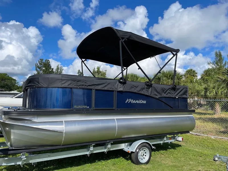 Slide: The Image of 2022 Manitou 18 Aurora LE Twin Tube 25 pontoon boat on trailer under blue sky. - 5