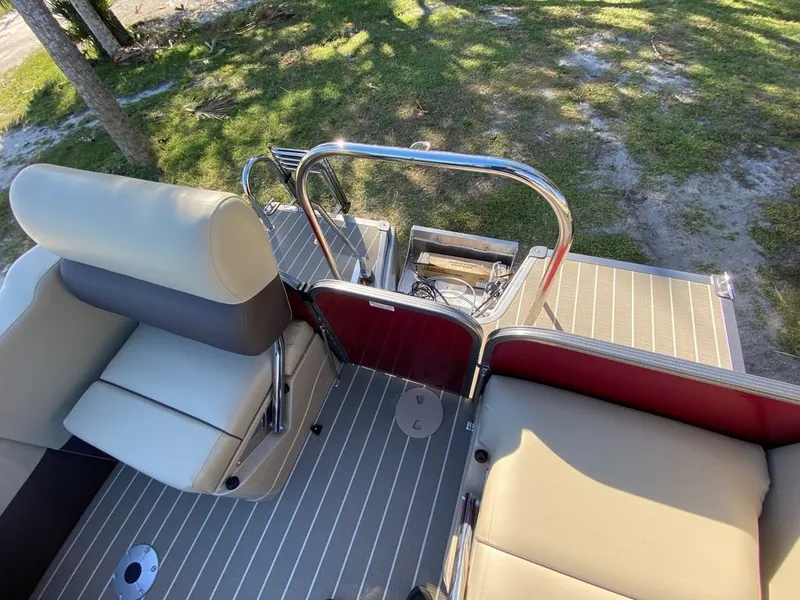 Slide: The Image of 2022 Manitou 23 Oasis SR VP boat interior with beige seating and striped flooring. - 15