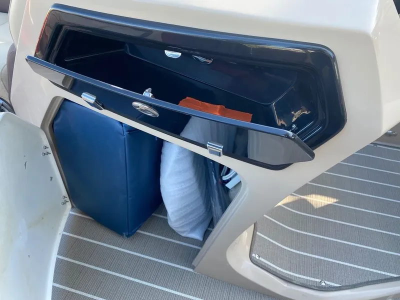 Slide: The Image of Storage compartment of 2022 Manitou 23 Oasis SR VP boat with open hatch. - 19