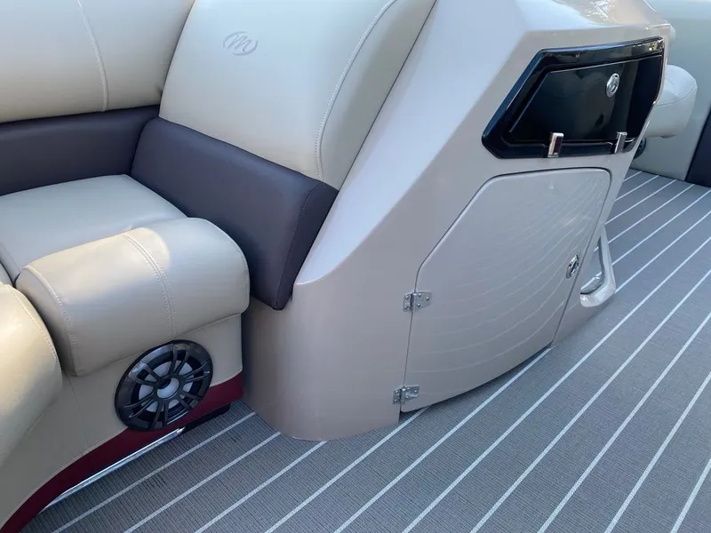 Slide: The Image of 2022 Manitou 23 Oasis SR VP boat interior with beige seating and storage compartment. - 21