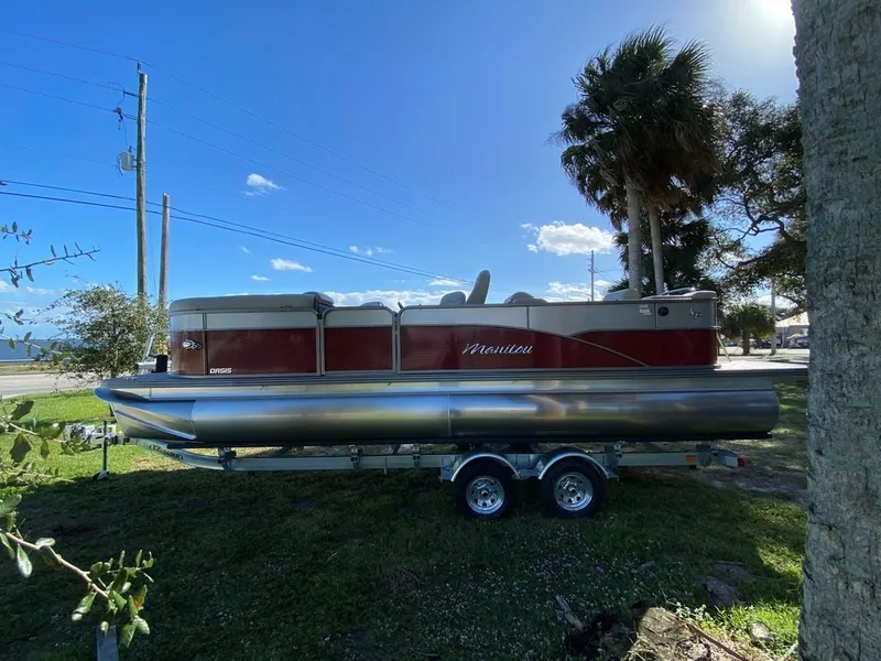 Slide: The Image of 2022 Manitou 23 Oasis SR VP pontoon boat on trailer, parked outdoors. - 6