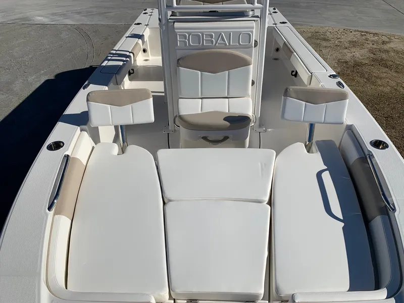 Slide: The Image of 2024 Robalo 226 Cayman boat interior with cushioned seating and storage. - 13