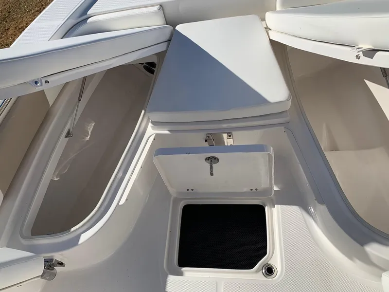 Slide: The Image of 2024 Robalo 226 Cayman boat storage compartments and seating area. - 14