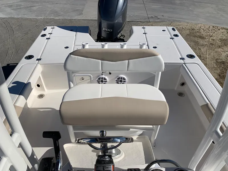 Slide: The Image of 2024 Robalo 226 Cayman boat interior with cushioned seating and outboard motor. - 5