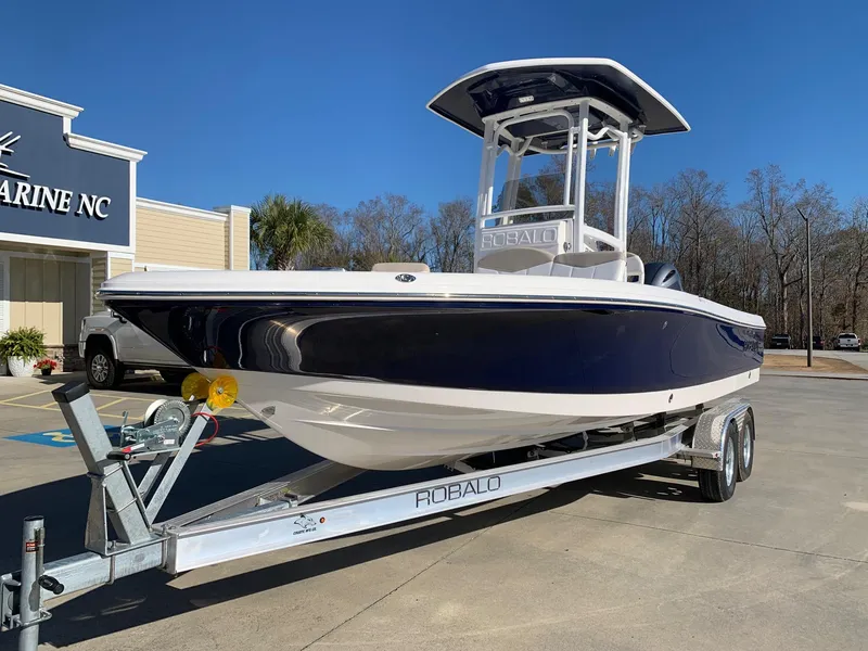 Slide: The Image of 2024 Robalo 226 Cayman boat on a trailer at a dealership. - 1