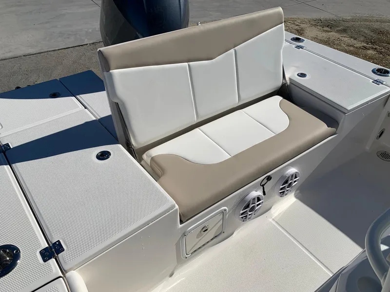 Slide: The Image of 2024 Robalo 226 Cayman boat seating area with storage compartments and speakers. - 8