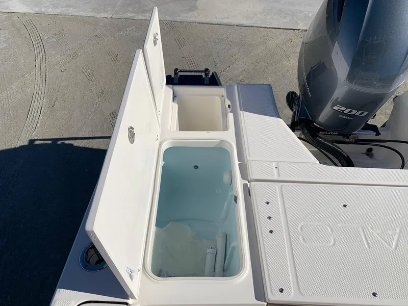 Slide: The Image of 2024 Robalo 226 Cayman boat with open storage compartments and 200 HP engine. - 9