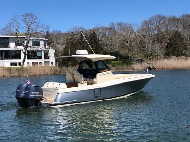 Slide: The Image of 2021 Chris-Craft Catalina 30 boat on a calm lake with modern house in background. - 3