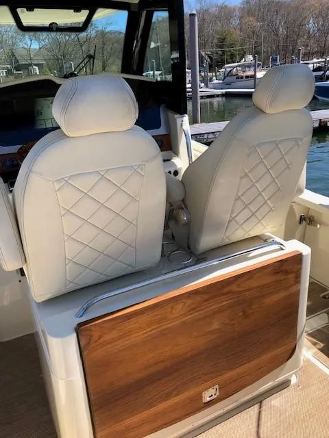 Slide: The Image of 2021 Chris-Craft Catalina 30 boat interior with white leather seats and wooden accents. - 7