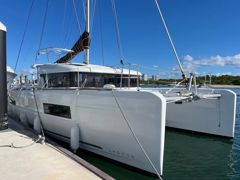 Slide: The Image of 2025 Lagoon 40 catamaran docked in sunny marina. - 2
