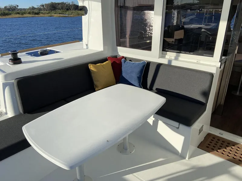 Slide: The Image of 2025 Lagoon 40 yacht seating area with colorful cushions and a white table. - 5