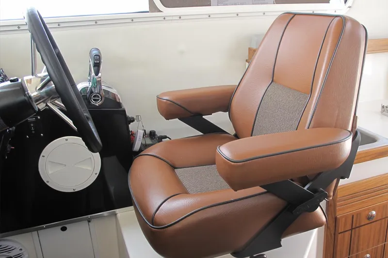 Slide: The Image of Captain's chair in 2026 SeaSport Kodiak 2600 boat, featuring brown leather upholstery. - 5