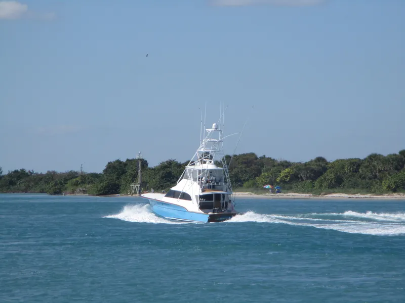 Slide: The Image of 2008 Custom Carolina 53 Sculley yacht cruising near a lush, green shoreline. - 2
