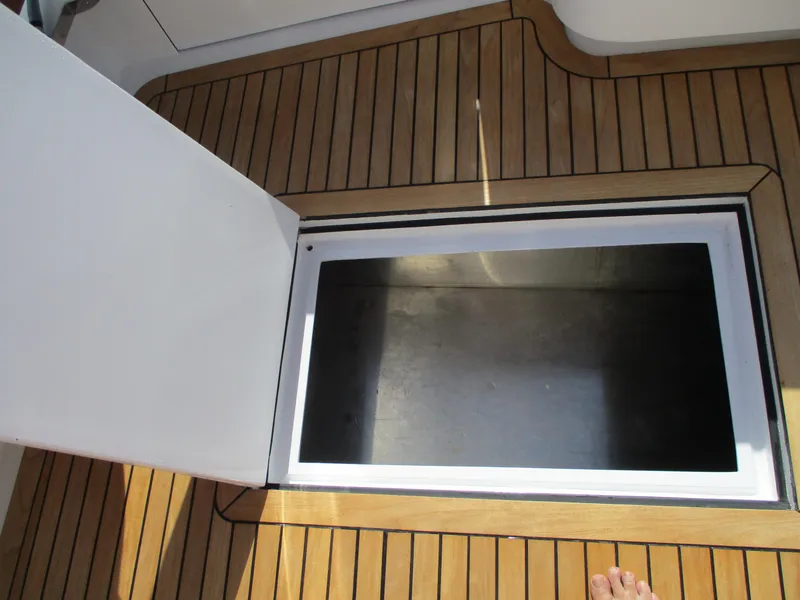 Slide: The Image of Open storage compartment on 2008 Custom Carolina 53 Sculley boat with teak flooring. - 27