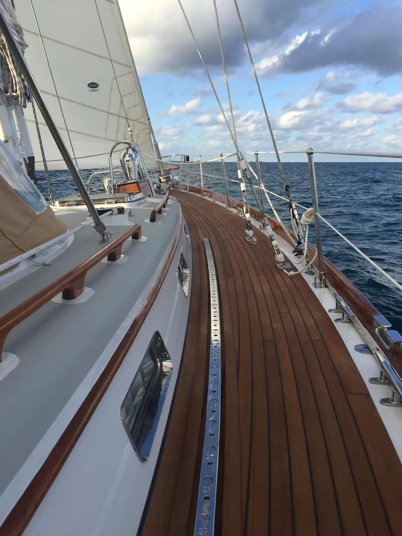 Slide: The Image of 1989 Little Harbor 54 sailboat with teak deck sailing on open sea under cloudy sky. - 2
