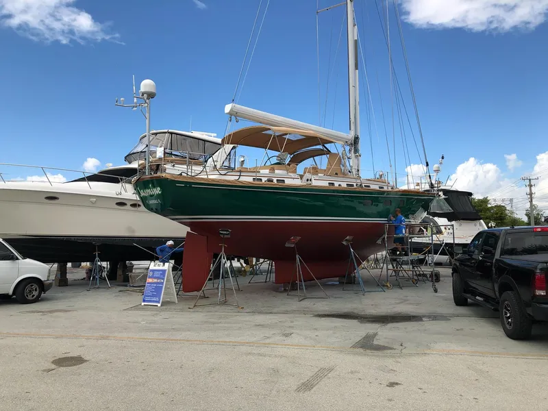 Slide: The Image of 1989 Little Harbor 54 sailboat on dry dock, surrounded by other boats and vehicles. - 3