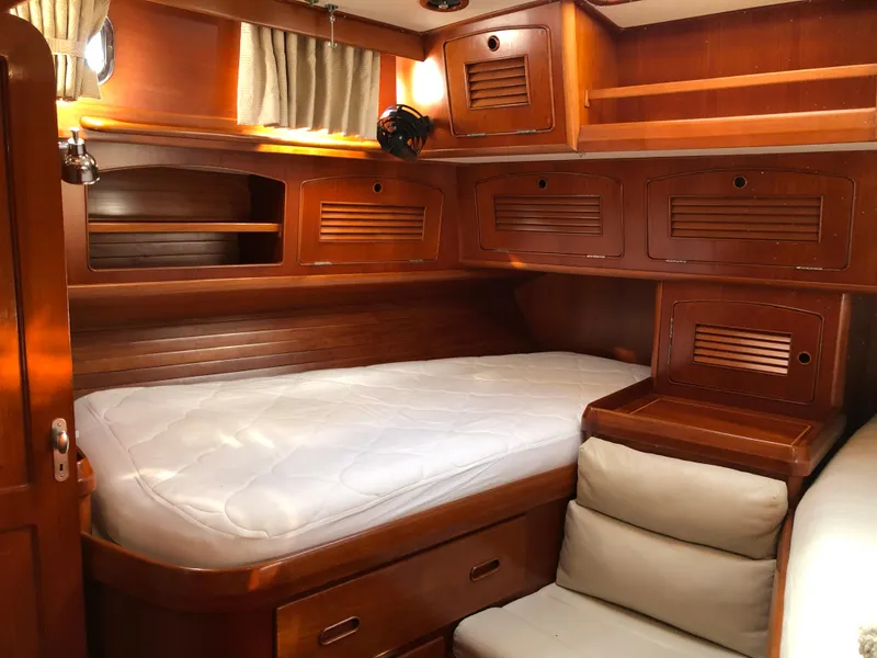 Slide: The Image of Luxurious wooden cabin interior of a 1989 Little Harbor 54 yacht with cozy bed and storage. - 39
