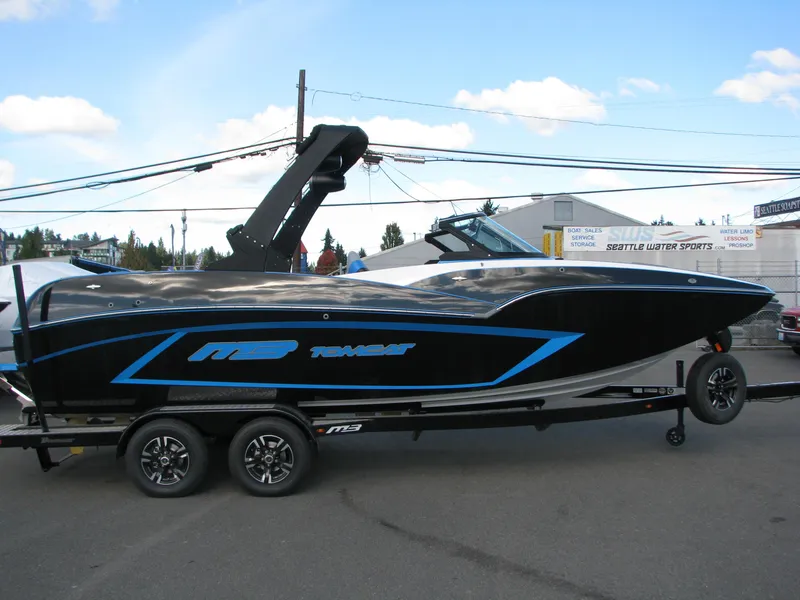 The Image of 2022 MB F22 Alpha boat with sleek black and blue design on trailer. - 0