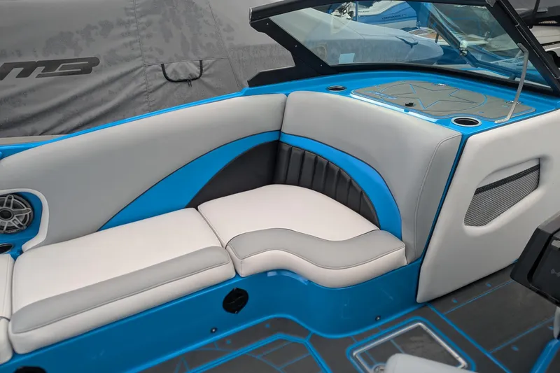 Slide: The Image of 2022 MB F22 Alpha boat interior with blue and gray seating, speaker, and cup holder. - 12
