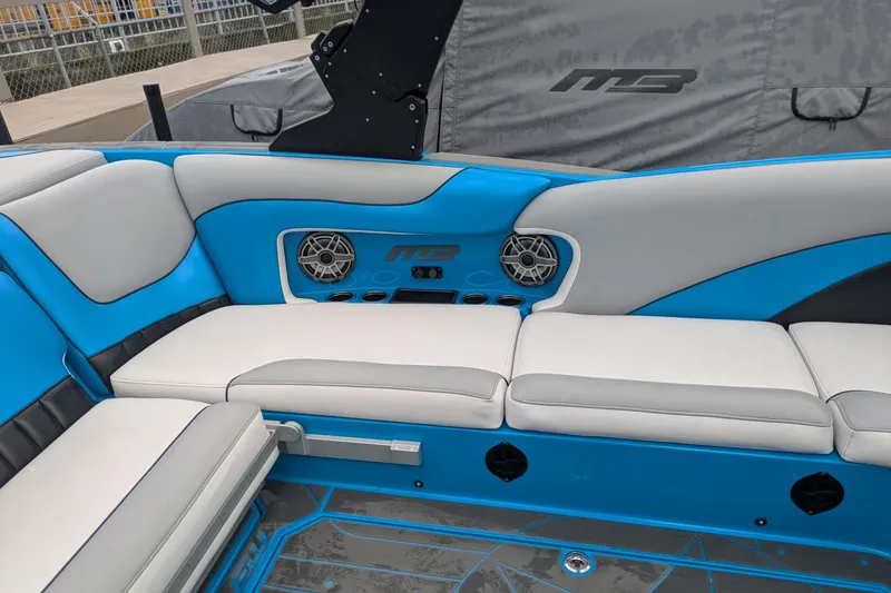 Slide: The Image of Interior of 2022 MB F22 Alpha boat with blue and white seating and speakers. - 13