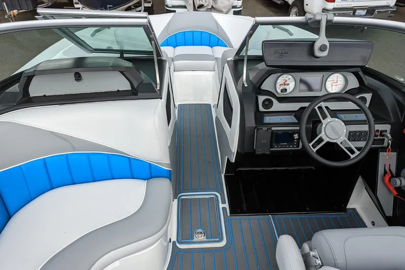 Slide: The Image of Interior of 2022 MB B52-21 Classic boat with modern dashboard and blue-accented seating. - 11