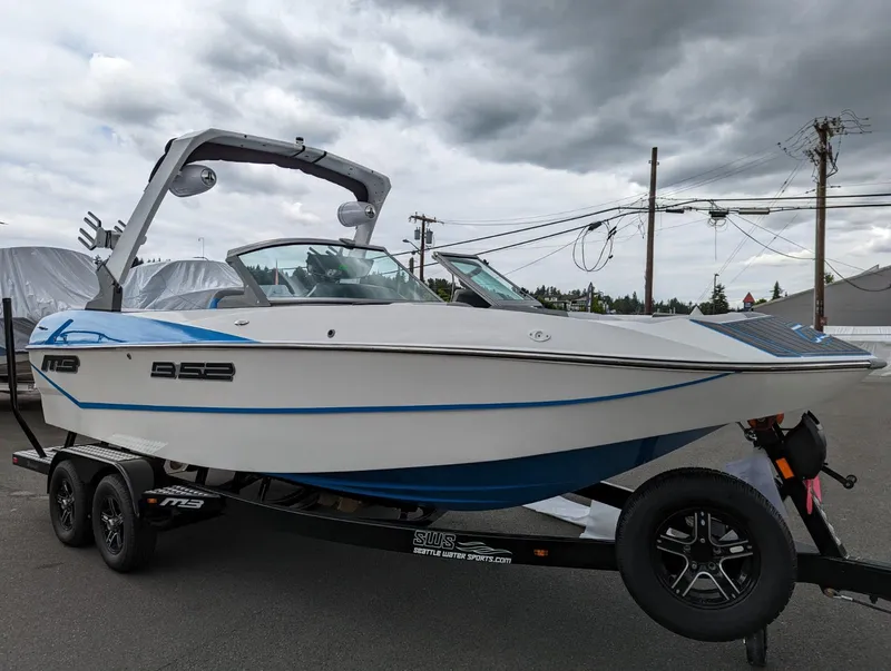 Slide: The Image of 2022 MB B52-21 Classic boat on trailer, white and blue, overcast sky. - 2