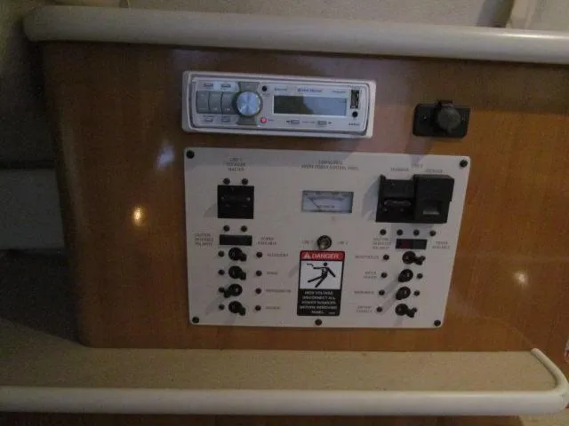 Slide: The Image of Control panel of a 2002 Bayliner 2655 Ciera Sunbridge boat, featuring various switches and a stereo. - 14