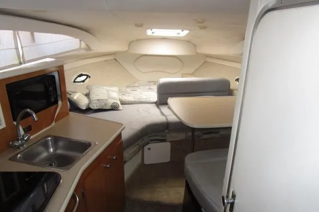 Slide: The Image of 2002 Bayliner 2655 Ciera Sunbridge cabin interior with kitchenette, seating, and bed. - 25