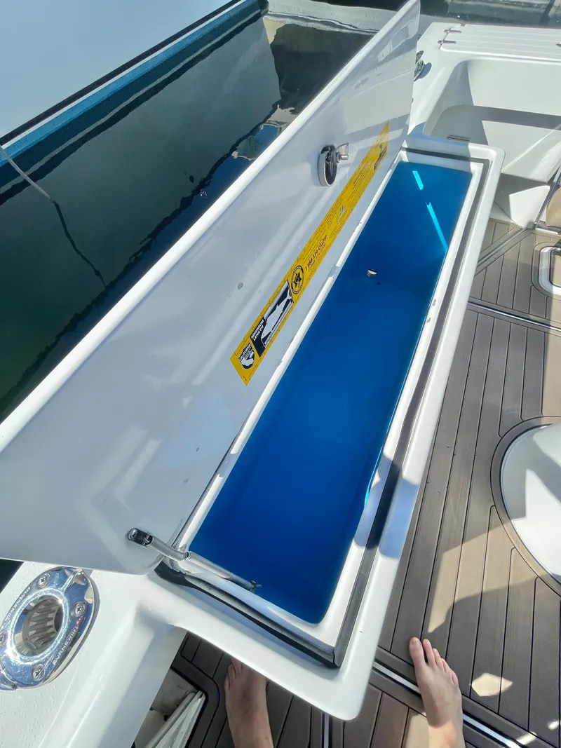 Slide: The Image of Open storage compartment on a 2017 Parker 2320 Sport Cabin boat. - 17