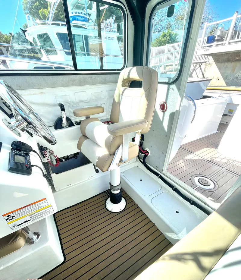 Slide: The Image of 2017 Parker 2320 Sport Cabin interior with captain's chair and steering console. - 3