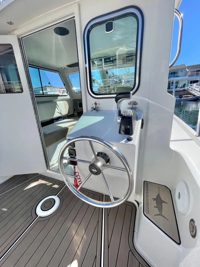 Slide: The Image of 2017 Parker 2320 Sport Cabin boat helm station with steering wheel and controls. - 6