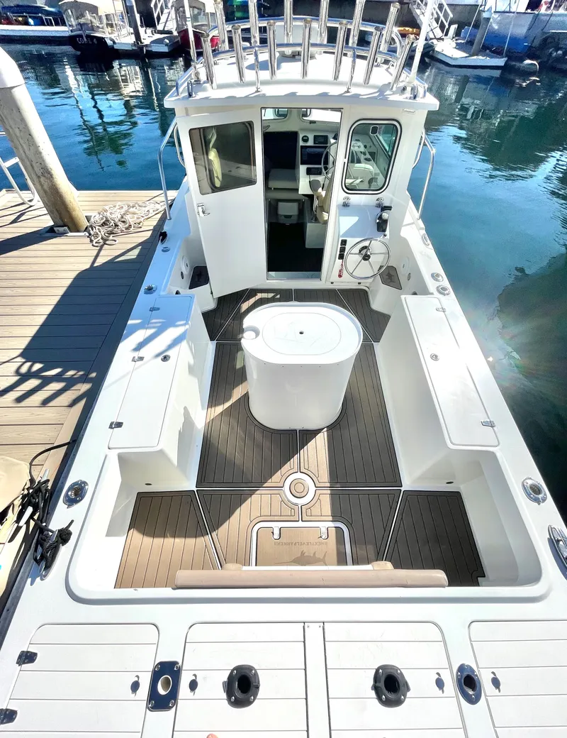 Slide: The Image of 2017 Parker 2320 Sport Cabin boat docked at marina, spacious deck view. - 7