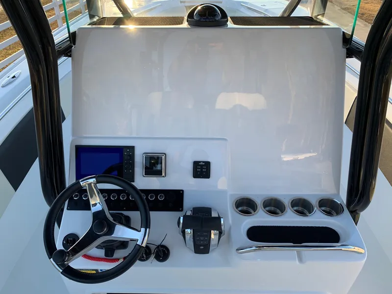 Slide: The Image of 2024 Cape Horn 32T boat dashboard with steering wheel, controls, and cup holders. - 13