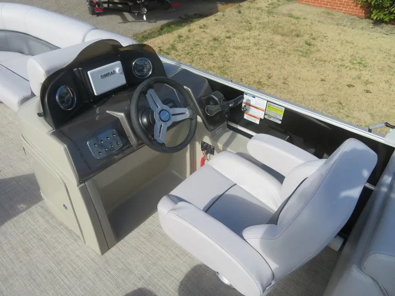 Slide: The Image of 2022 Coach Pontoons 241 RFC boat helm with steering wheel and captain's chair. - 6