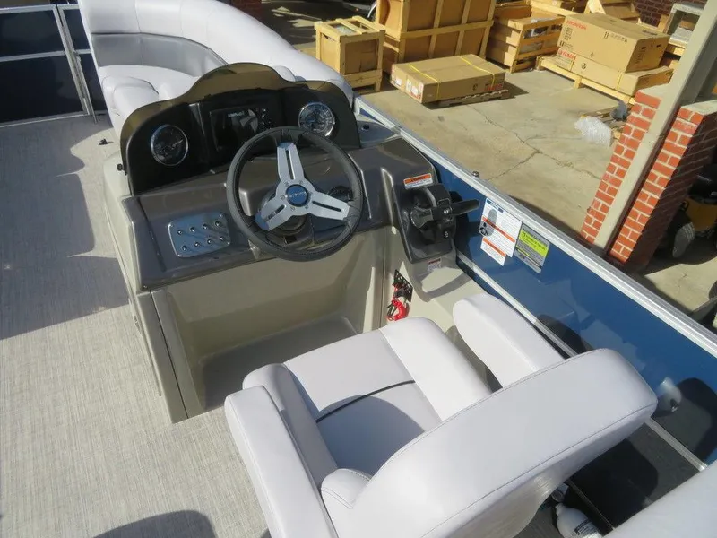 Slide: The Image of 2022 Coach Pontoons 241 RFC boat helm with steering wheel and control panel. - 13