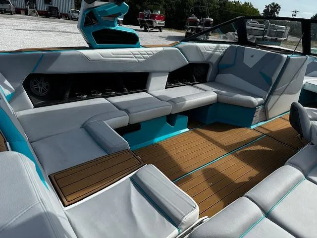 Slide: The Image of 2022 Nautique S23 boat interior with modern seating and teak flooring. - 11