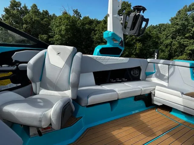 Slide: The Image of 2022 Nautique S23 boat interior with gray seating and blue accents. - 14