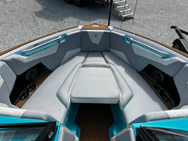 Slide: The Image of 2022 Nautique S23 boat interior with cushioned seating and cup holders. - 17