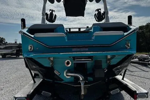 Slide: The Image of 2022 Nautique S23 boat rear view on trailer, showcasing sleek design and vibrant blue color. - 18