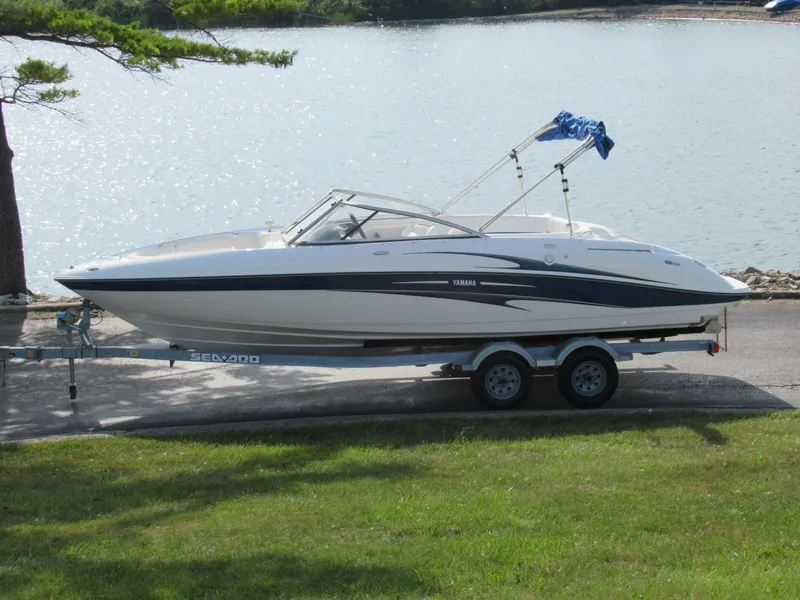 Slide: The Image of 2004 Yamaha Boats SX230 on trailer by a lake. - 0
