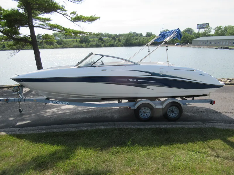 Slide: The Image of 2004 Yamaha Boats SX230 on trailer by a lake. - 9