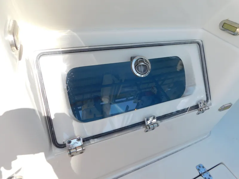 Slide: The Image of ShearWater 250 XTE 2022 boat compartment with secure latch and clear window. - 13