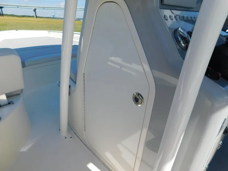 Slide: The Image of 2022 ShearWater 250 XTE boat console with storage compartment and seating area. - 16