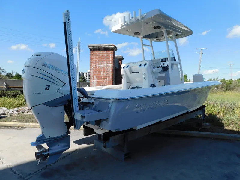 Slide: The Image of 2022 ShearWater 250 XTE boat with outboard motor, parked outdoors. - 2