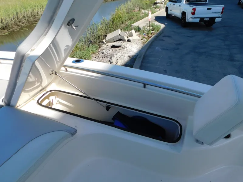 Slide: The Image of Open storage compartment on 2022 ShearWater 250 XTE boat near a riverside parking area. - 23