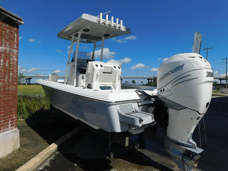 Slide: The Image of 2022 ShearWater 250 XTE boat with Mercury engine, docked outdoors under a clear sky. - 40