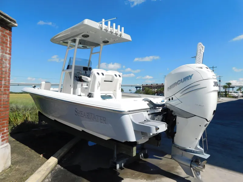 Slide: The Image of 2022 ShearWater 250 XTE boat with Mercury engine, parked outdoors under blue sky. - 42