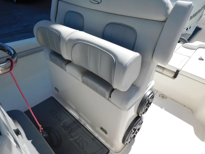 Slide: The Image of 2022 ShearWater 250 XTE boat seating with dual speakers and cushioned backrest. - 6