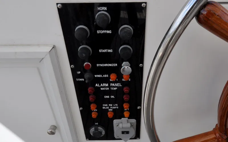 Slide: The Image of Control panel of a 2000 Grand Banks Heritage Europa 52 yacht, featuring various switches and indicators. - 34