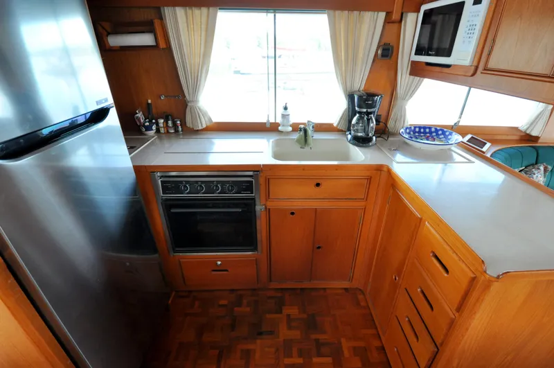 Slide: The Image of Kitchen area of 2000 Grand Banks Heritage Europa 52 yacht with appliances and wooden cabinetry. - 46